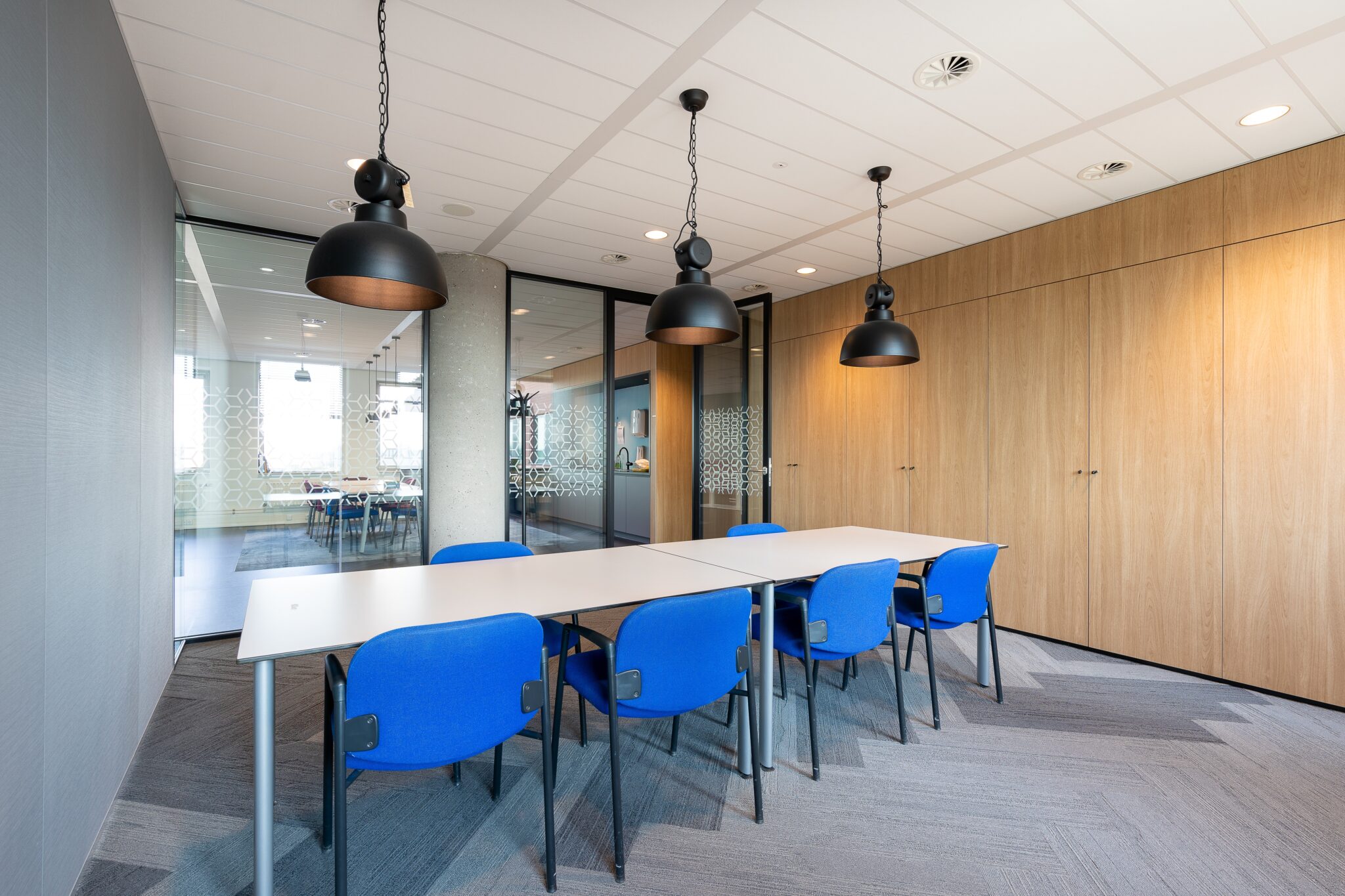 The meeting room interior of a modern office with a long wooden table and chairs around it